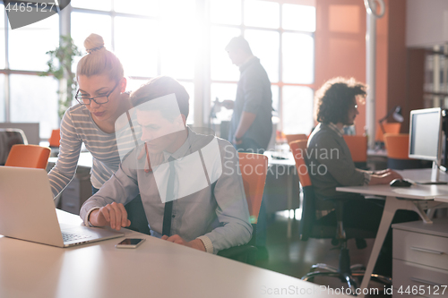 Image of Two Business People Working With laptop in office