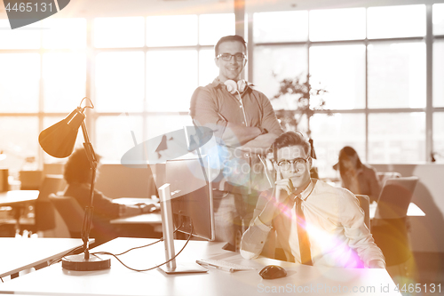 Image of Young businessman helping his colleague at the work