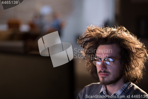 Image of man working on computer in dark office