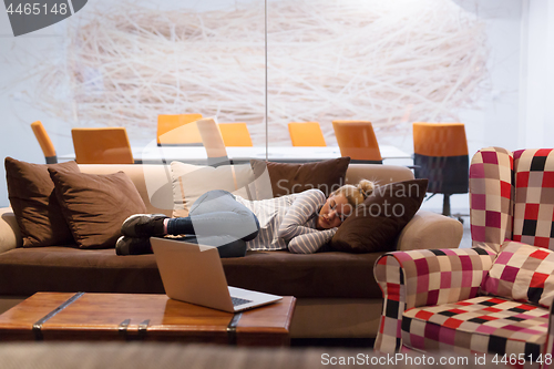 Image of woman sleeping on a sofa  in a creative office