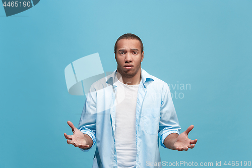 Image of Afro man looking suprised and bewildered isolated on blue