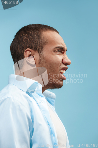 Image of The young emotional angry man on blue studio background