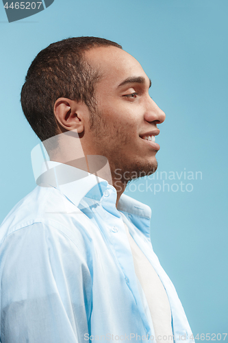 Image of The happy businessman standing and smiling against blue background.