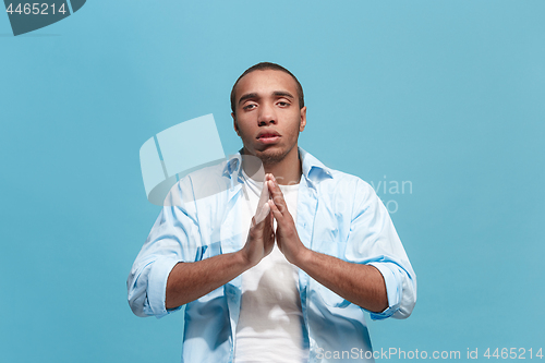 Image of The serious businessman standing and looking at camera against studio background.