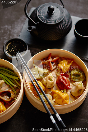 Image of Oriental traditional chinese dumplings served in the wooden steamer