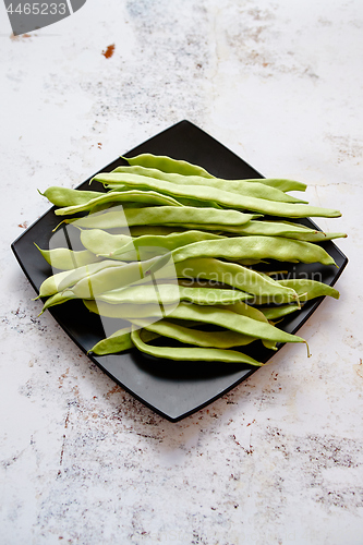 Image of Black ceramic plate with fresh green bean pods