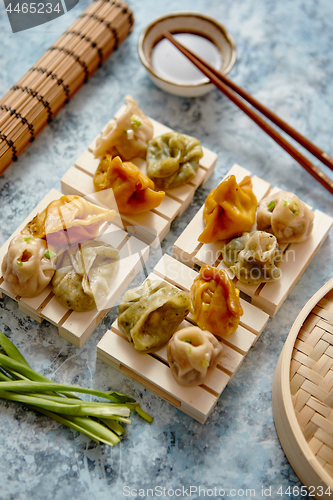 Image of Delicious mixed kinds of chinese dumplings served on wooden stands