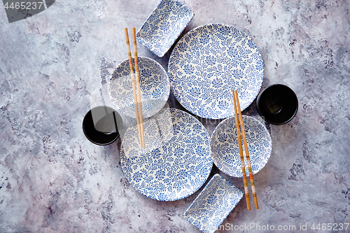 Image of Empty oriental style dishware set on gray stone background