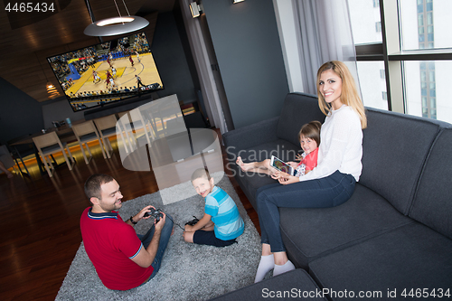 Image of Happy family playing a basketball video game