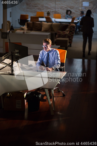 Image of man working on computer in dark office