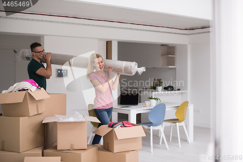 Image of couple carrying a carpet moving in to new home