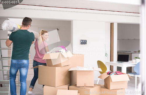 Image of couple carrying a carpet moving in to new home