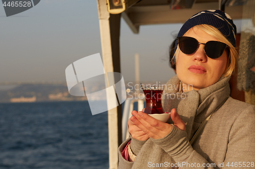 Image of Young woman drinking traditional Turkish tea