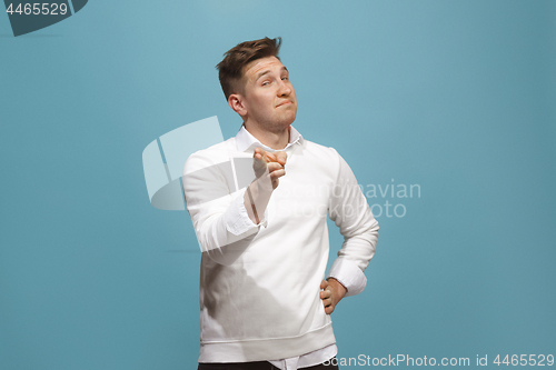 Image of The happy business man point you and want you, half length closeup portrait on blue background.