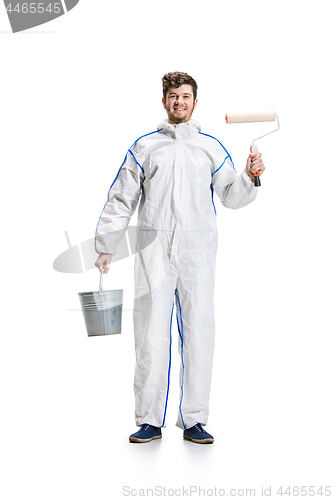 Image of Young male decorator painting with a paint roller climbed a ladder isolated on white background.