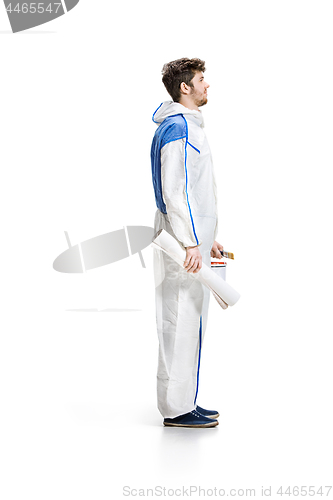 Image of Young male decorator painting with a paint roller climbed a ladder isolated on white background.