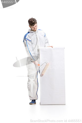 Image of Young male decorator painting with a poster climbed a ladder isolated on white background.