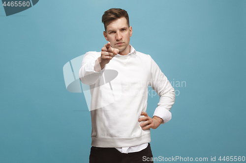Image of The overbearing businessman point you and want you, half length closeup portrait on blue background.