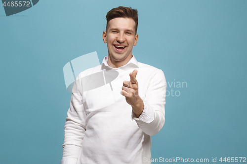 Image of The happy business man point you and want you, half length closeup portrait on blue background.