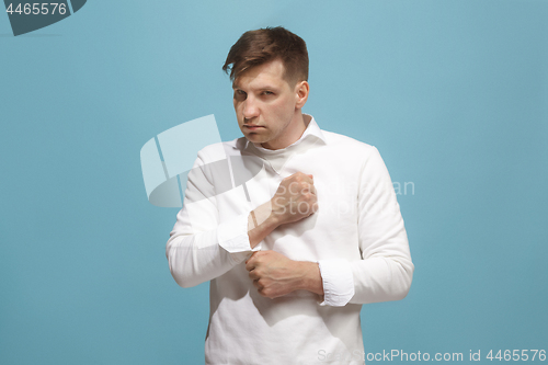 Image of The young emotional angry man screaming on blue studio background