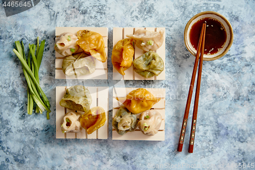 Image of Delicious mixed kinds of chinese dumplings served on wooden stands