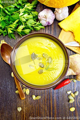 Image of Soup-puree pumpkin with seeds in bowl on wooden board top