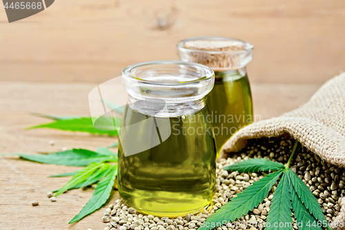 Image of Oil hemp in two jars with sheet on wooden board