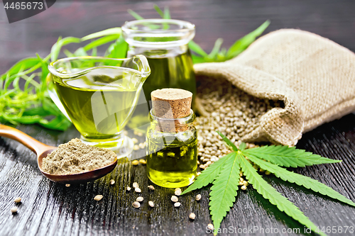 Image of Oil hemp in two jars and sauceboat on wooden board