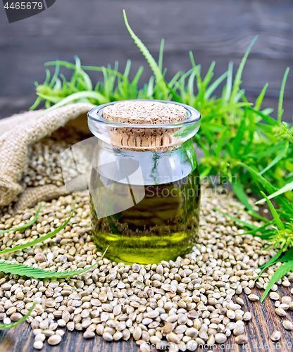 Image of Oil hemp in jar with seed on wooden board
