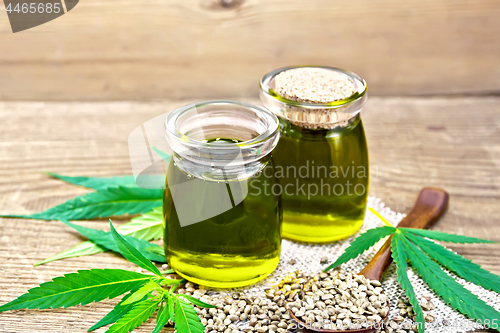 Image of Oil hemp in two jars and spoon on old board