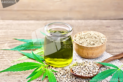Image of Oil hemp in jar with flour in bowl on wooden table