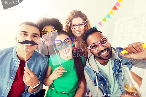 Image of happy friends or team having fun at office party