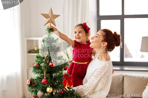 Image of mother and daughter decorating christmas tree