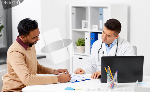 Image of doctor with laptop and male patient at hospital