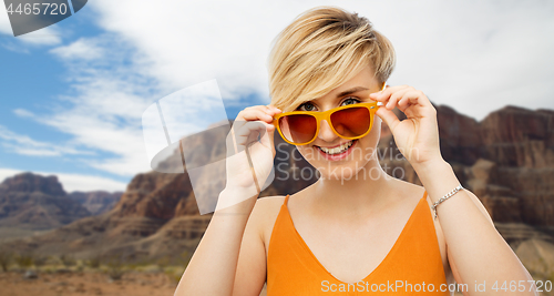 Image of portrait of smiling young woman in sunglasses