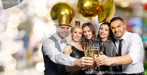 Image of happy friends clinking champagne glasses at party