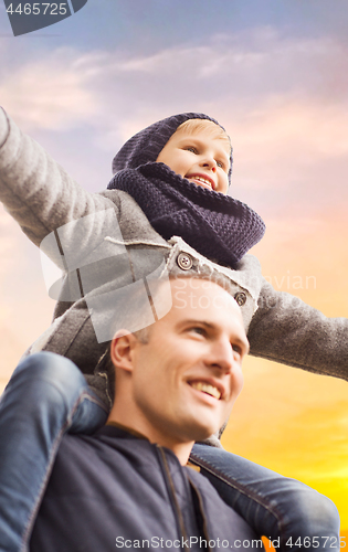 Image of happy father carrying son over sky background
