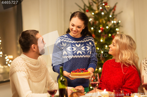 Image of happy friends having christmas dinner at home