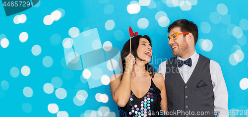 Image of happy couple with party props having fun