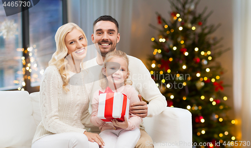 Image of happy family at home with christmas gift