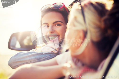 Image of happy teenage girls or women in car at seaside