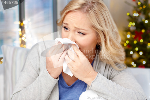 Image of close up of ill woman blowing nose on christmas