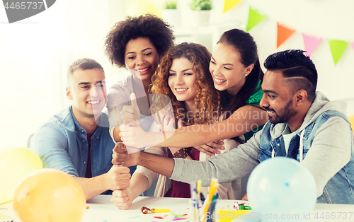 Image of happy team at office party showing thumbs up