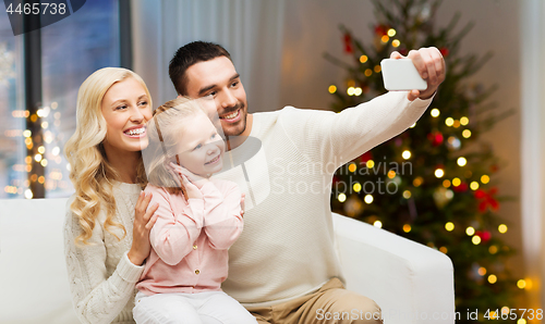 Image of family taking selfie by smartphone on christmas