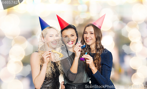 Image of happy women with party caps hugging