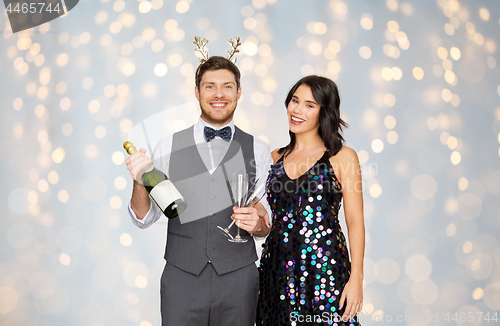 Image of couple with champagne bottle at christmas party