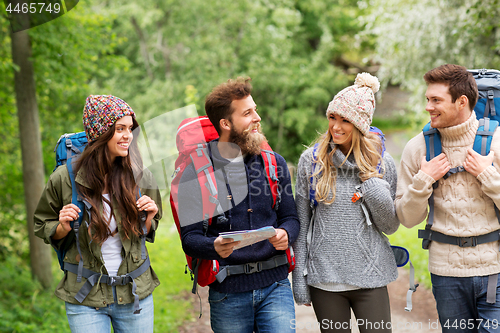 Image of friends or travelers hiking with backpacks and map