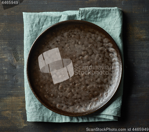 Image of Dark empty plate on wood table