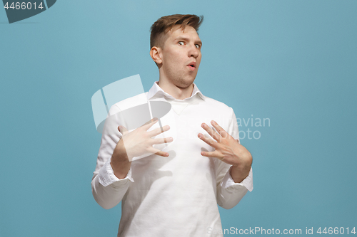 Image of The young attractive man looking suprised isolated on blue