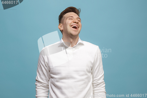 Image of The happy business man standing and smiling against blue background.